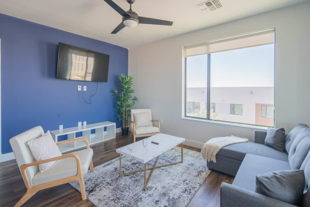 Bright furnished living room with sectional sofa and blue feature wall
